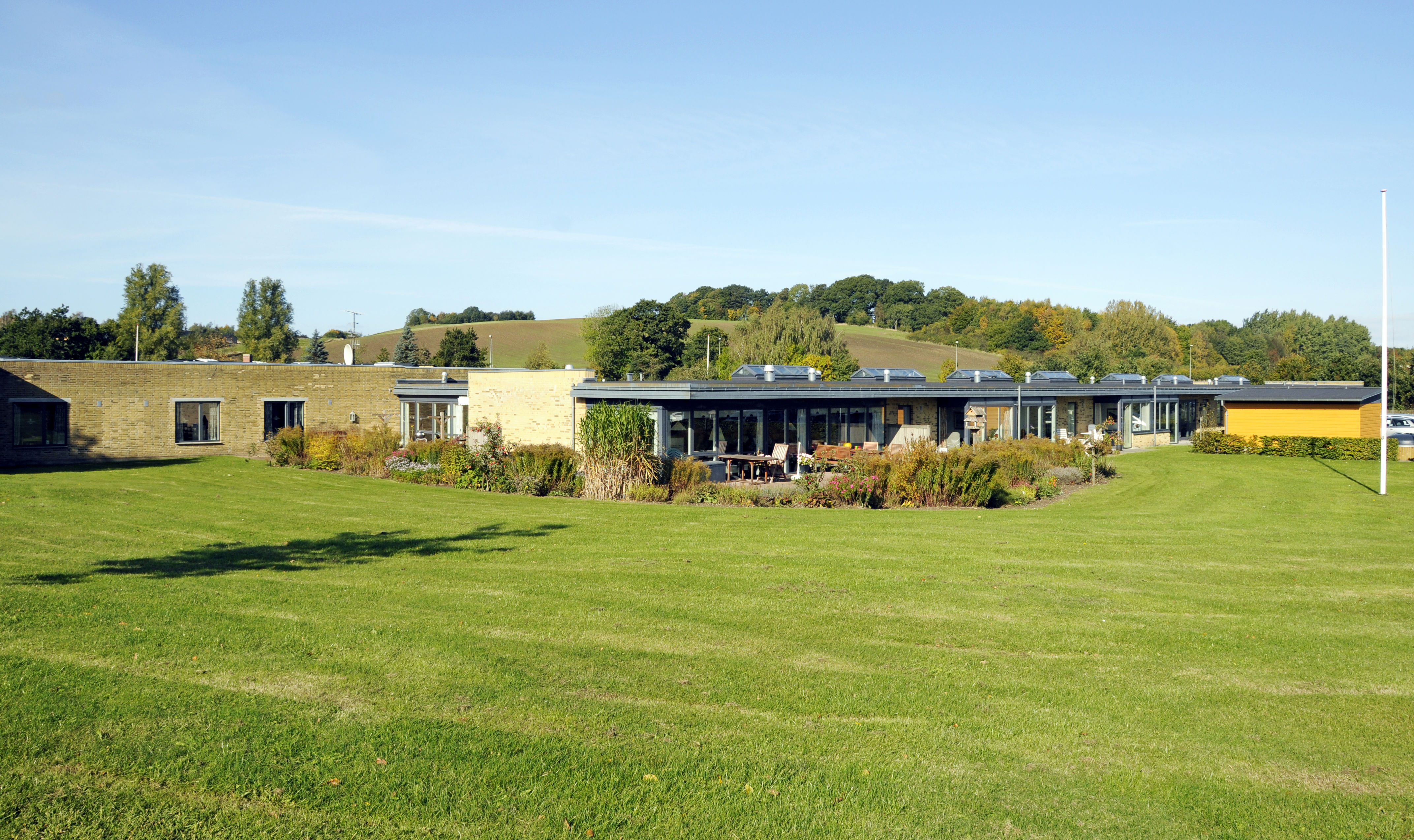 Have med græsplæne og flagstang hos Kildevang