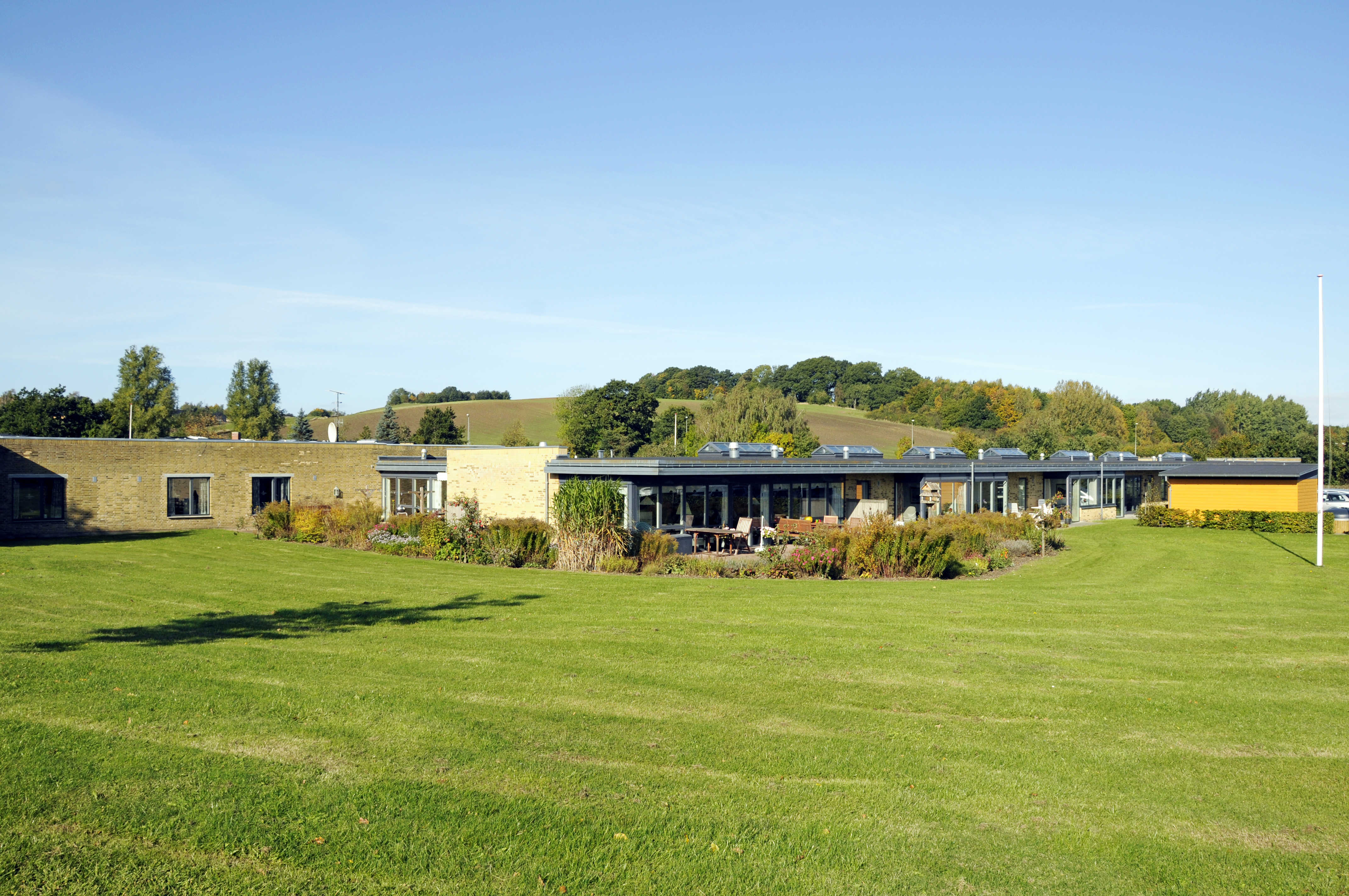 Have med græsplæne og flagstang hos Kildevang