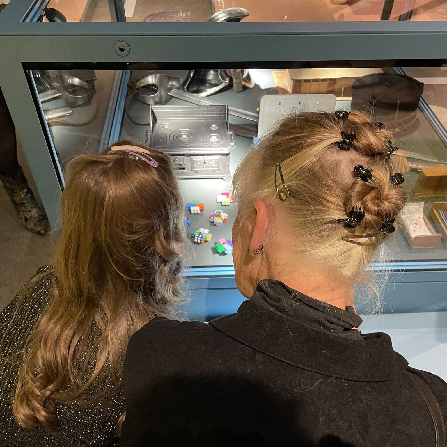 Barn og voksen kigger på genstande i montre