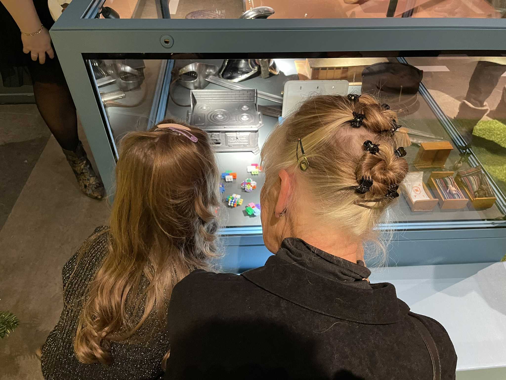 Barn og voksen kigger på genstande i montre