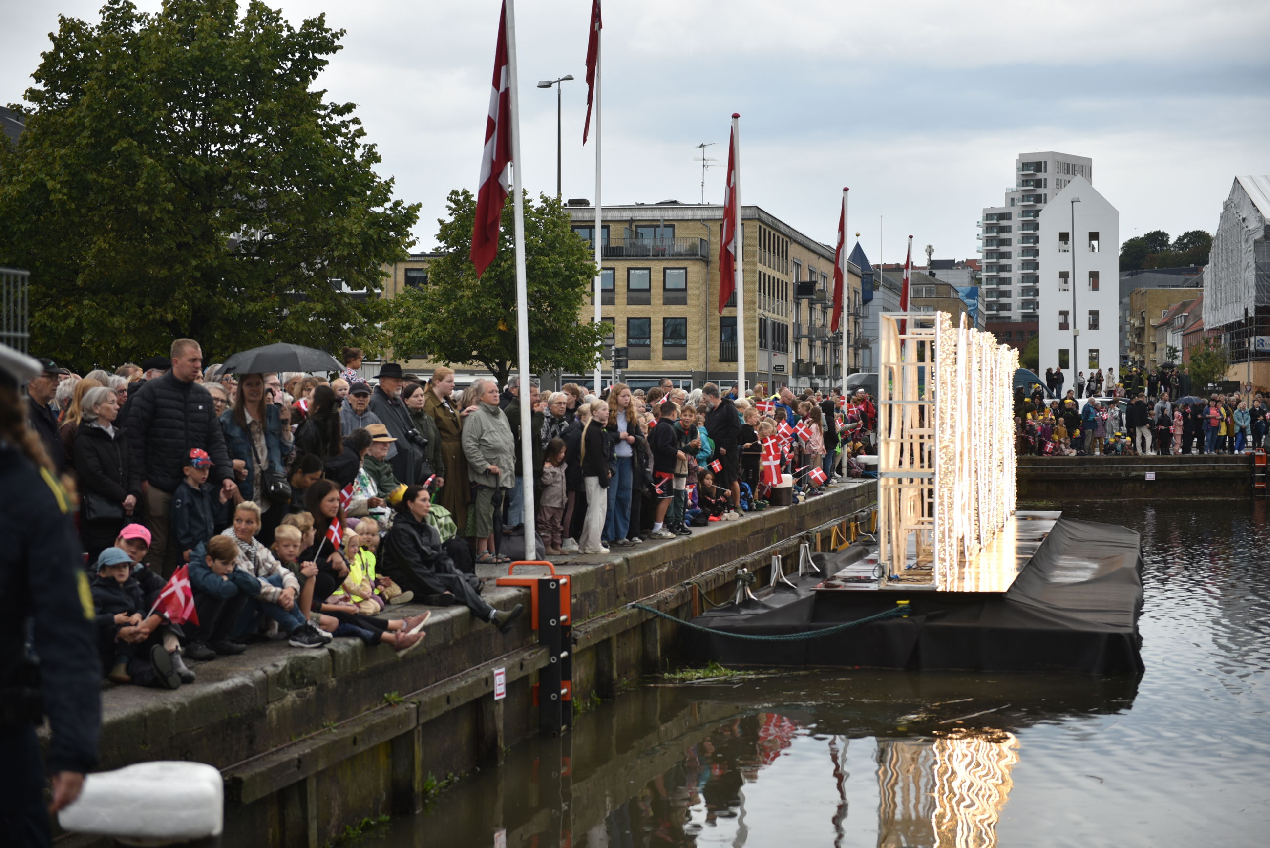 Folk står klar til at modtage Dronningen på havnen