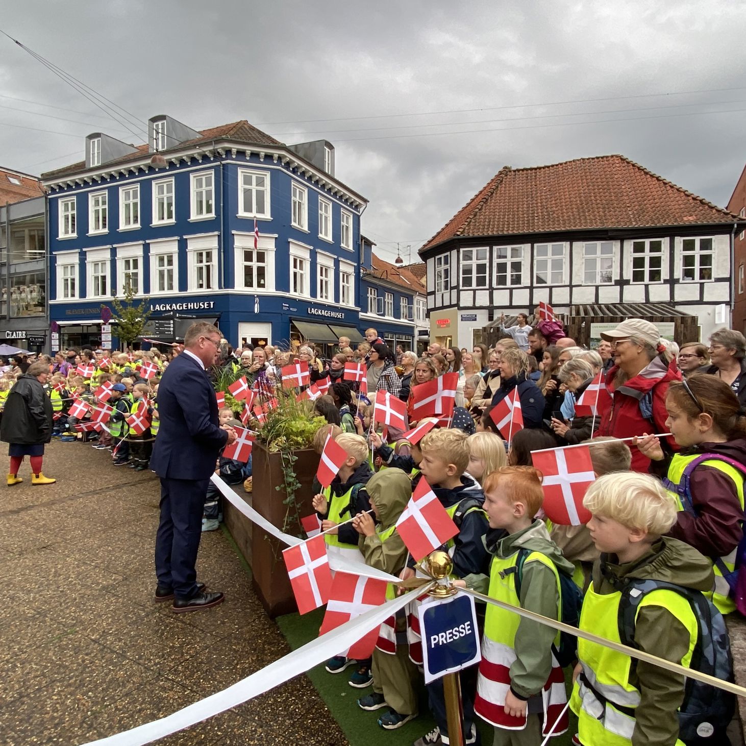 Borgmesteren hilser på folk, som står klar til at modtage Dronningen på Rådhustorvet.