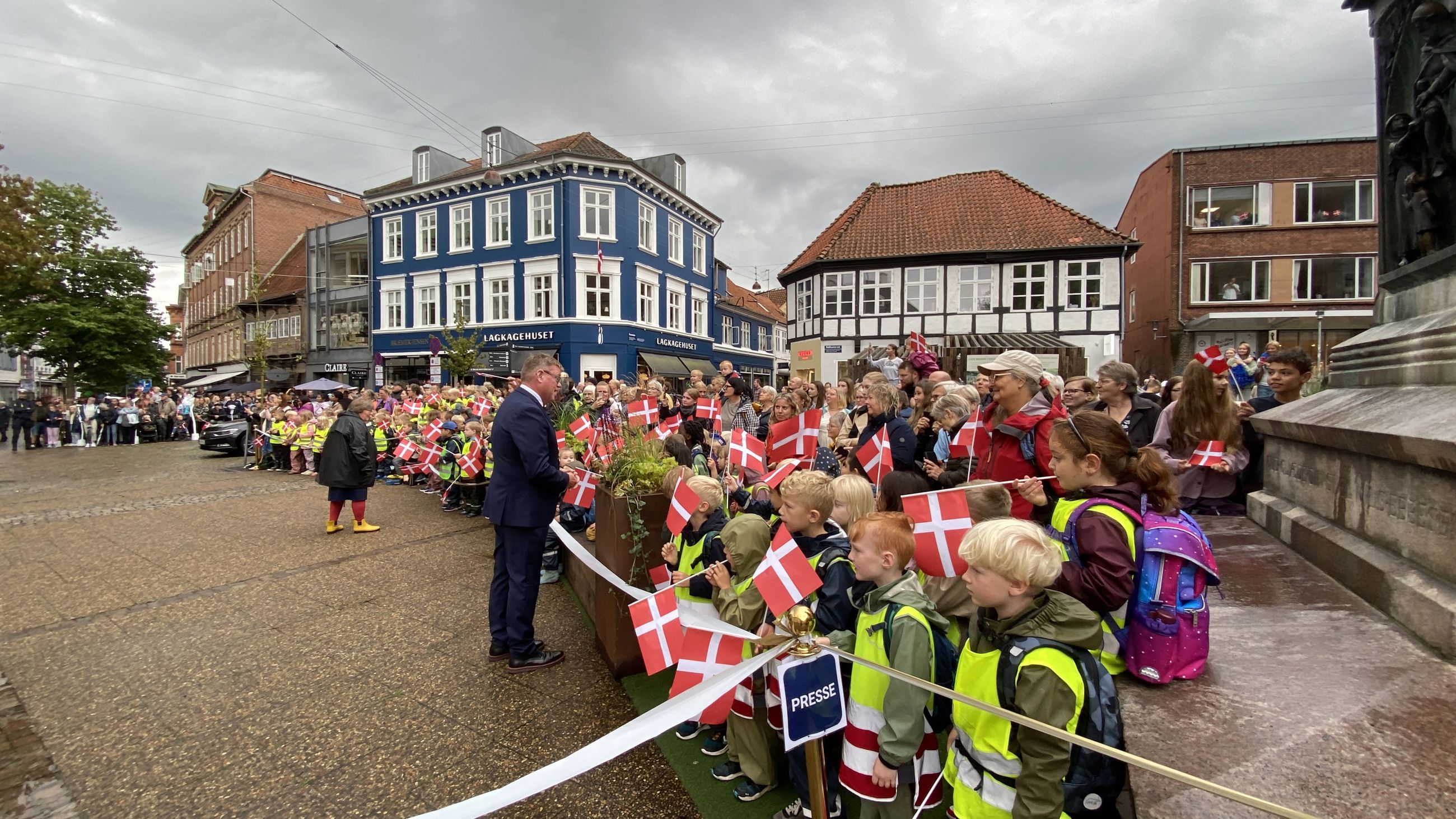 Borgmesteren hilser på folk, som står klar til at modtage Dronningen på Rådhustorvet.