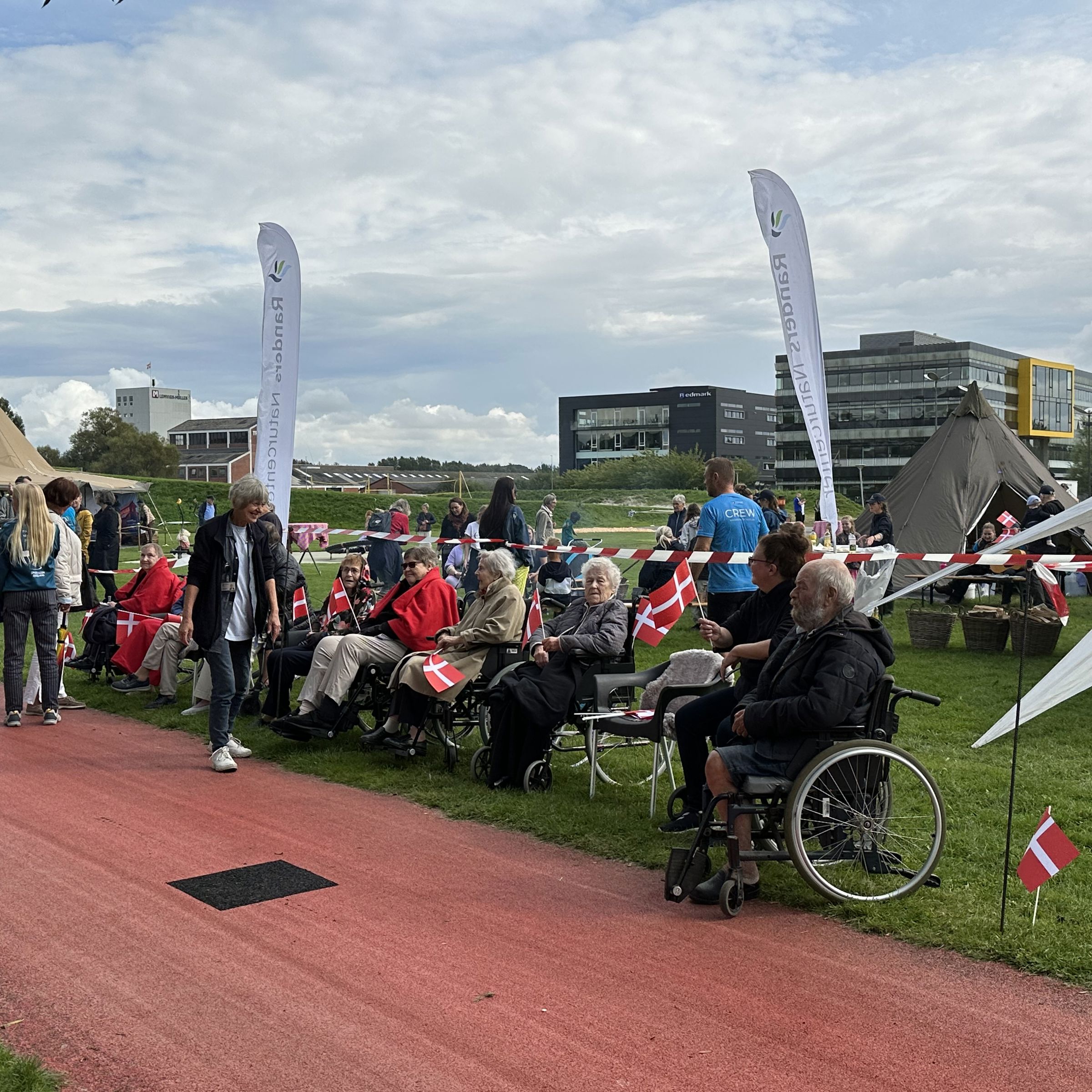 Folk er klar til at modtage Dronningen i Tronholmparken