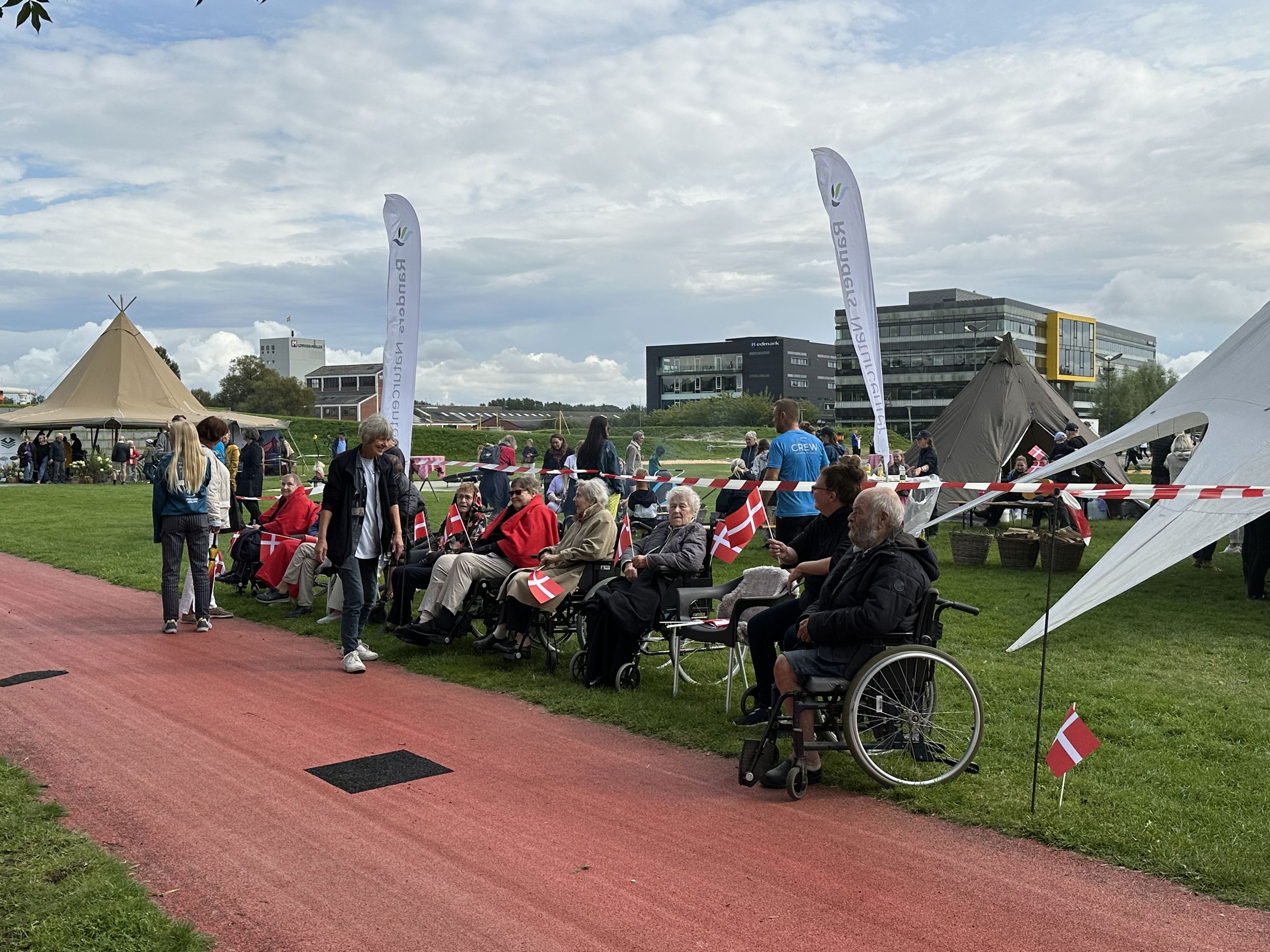 Folk er klar til at modtage Dronningen i Tronholmparken