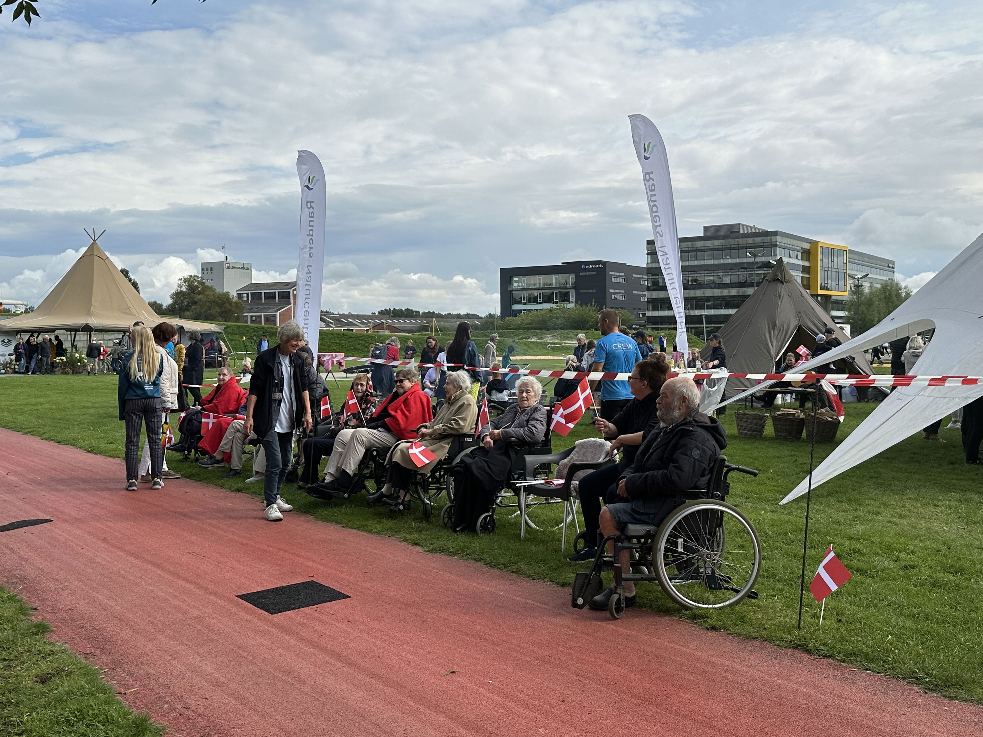Folk er klar til at modtage Dronningen i Tronholmparken