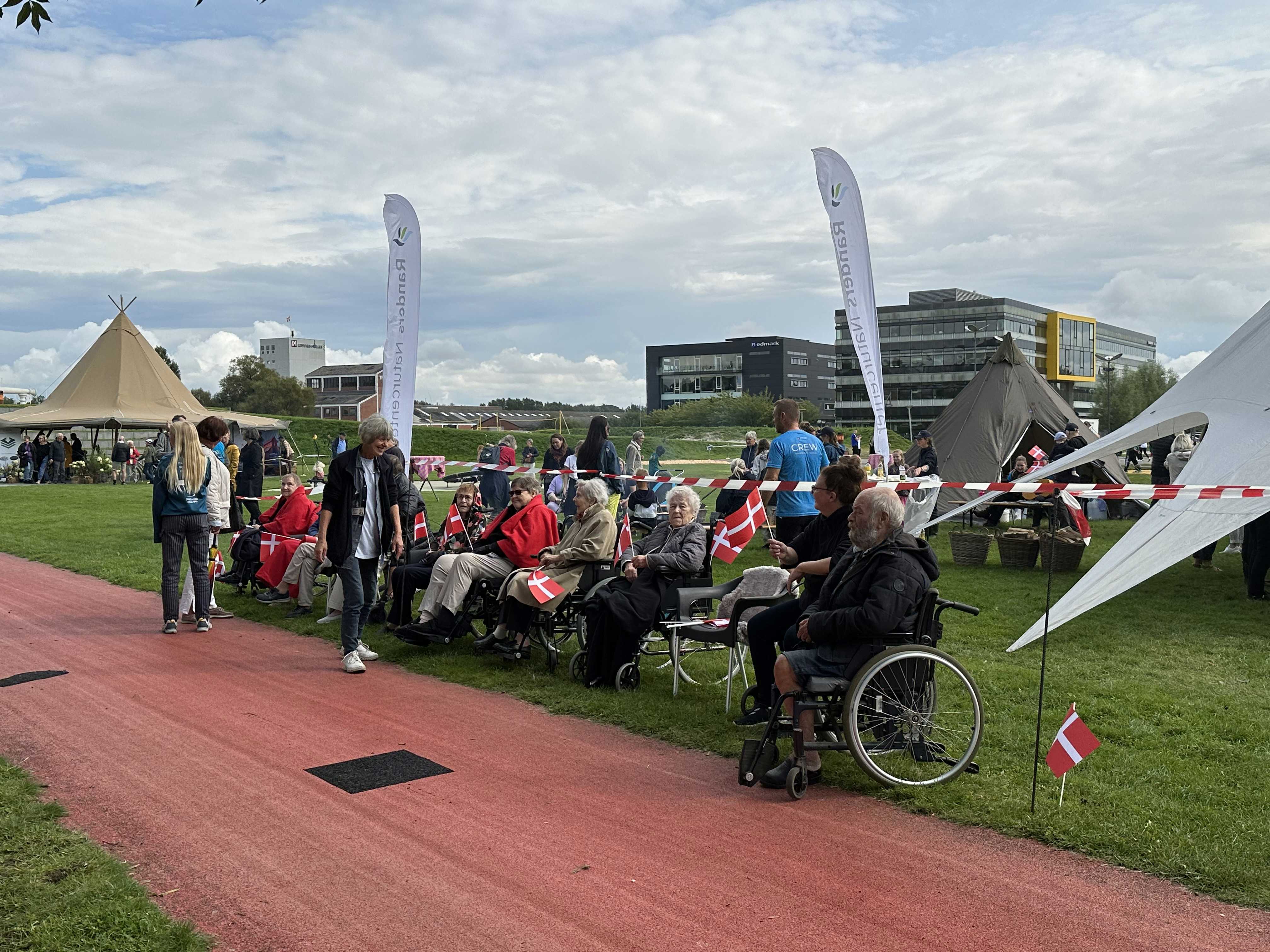 Folk er klar til at modtage Dronningen i Tronholmparken