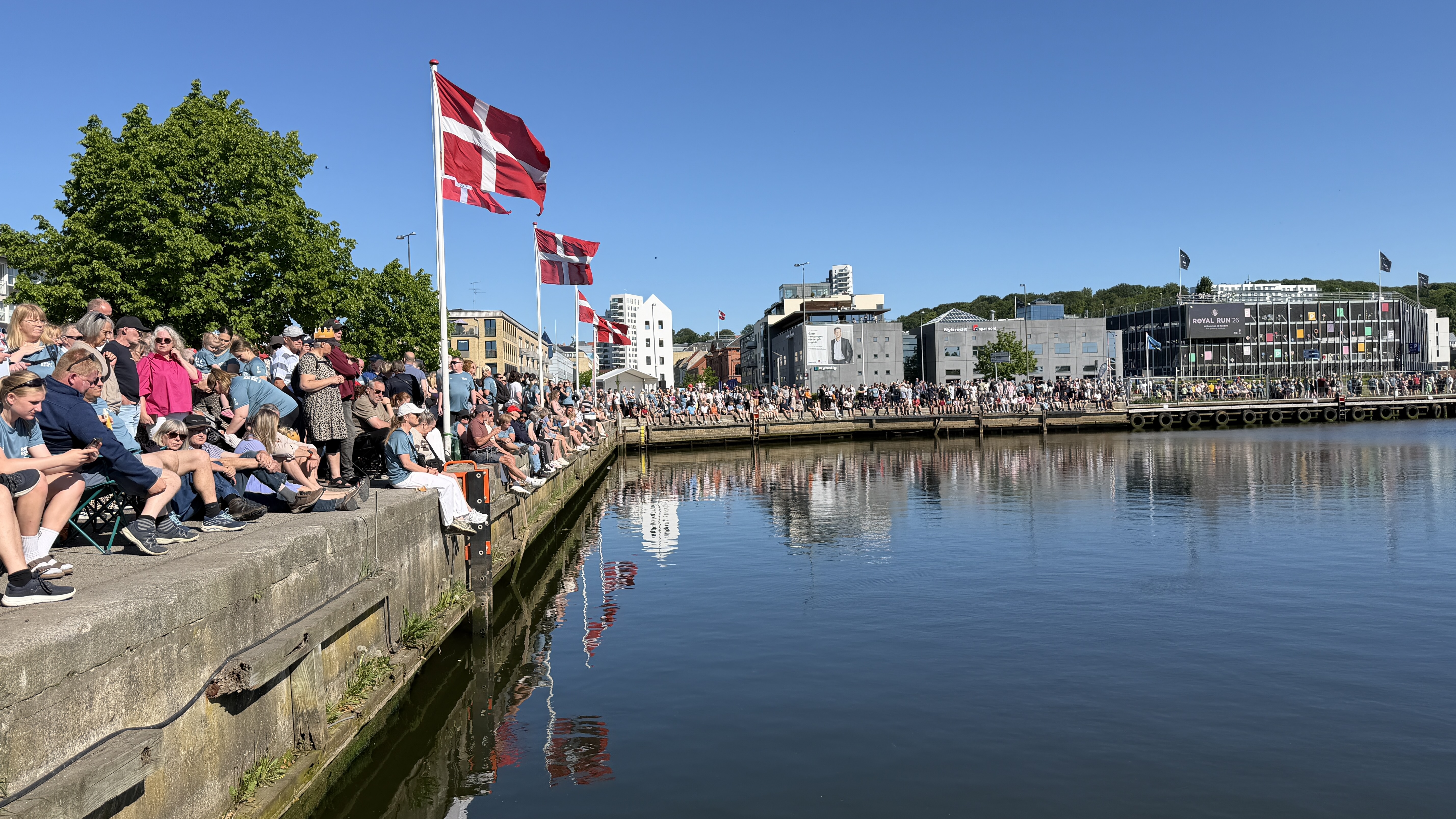 Publikum sidder i Randers Havn og venter på Kongen