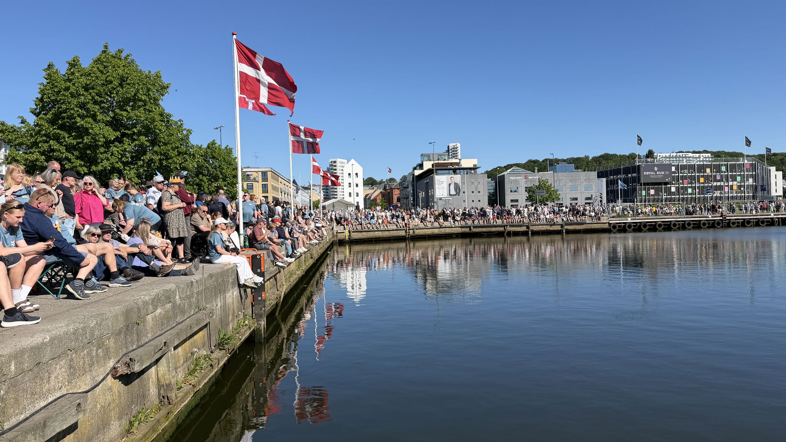 Publikum sidder i Randers Havn og venter på Kongen