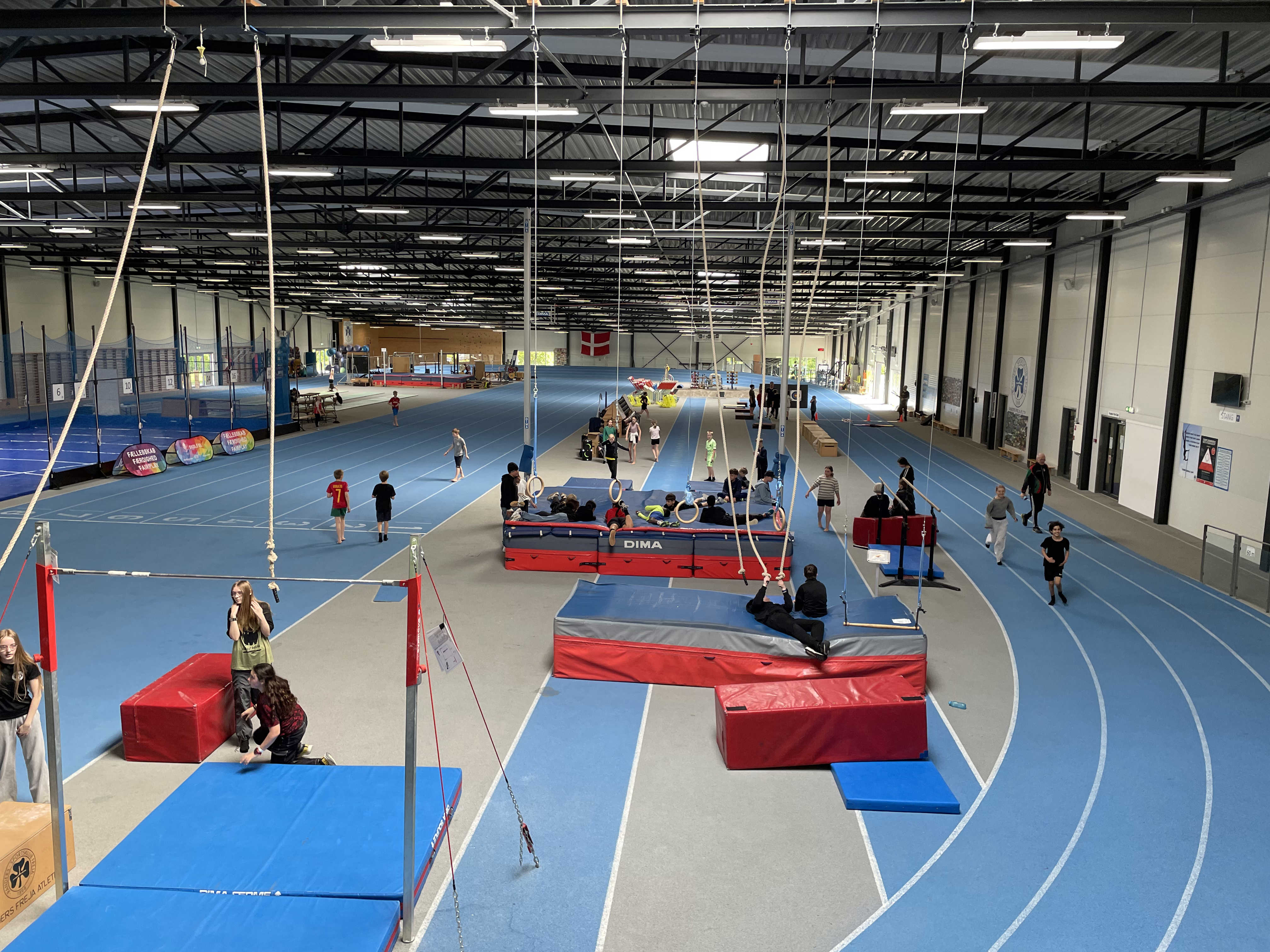 Udsigt over den indendørs løbebane, madrasser, ringe fra loftet til Skole OL