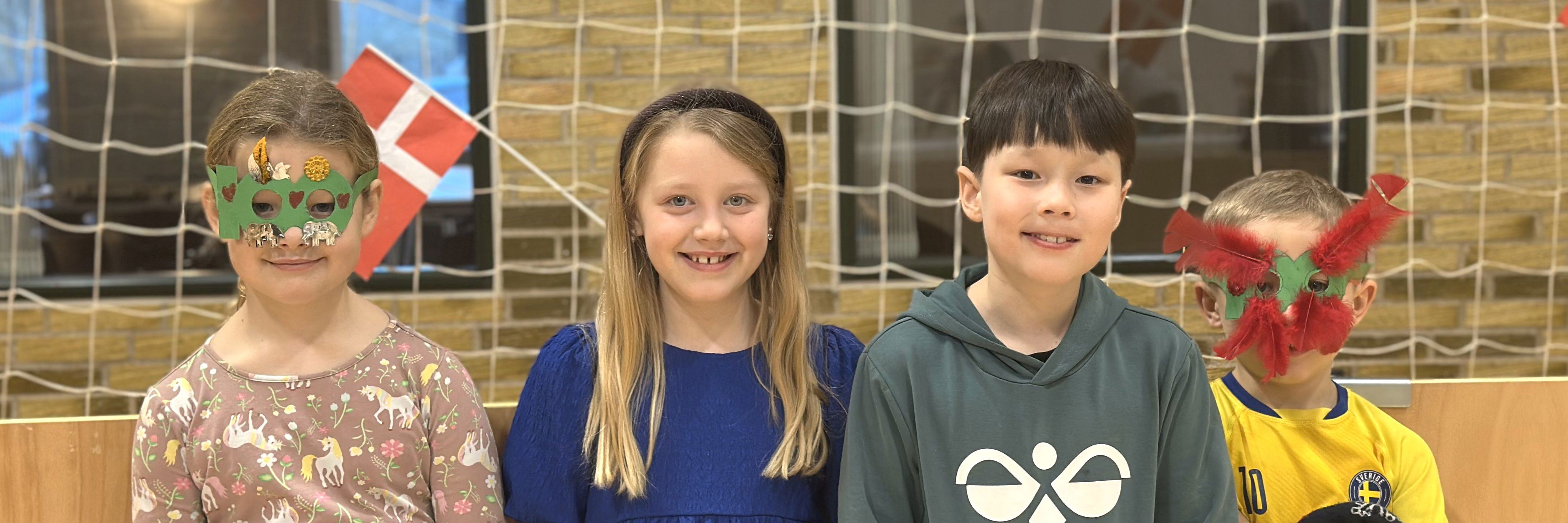 fire elever der står på en række. To har deres 100 dages briller på.