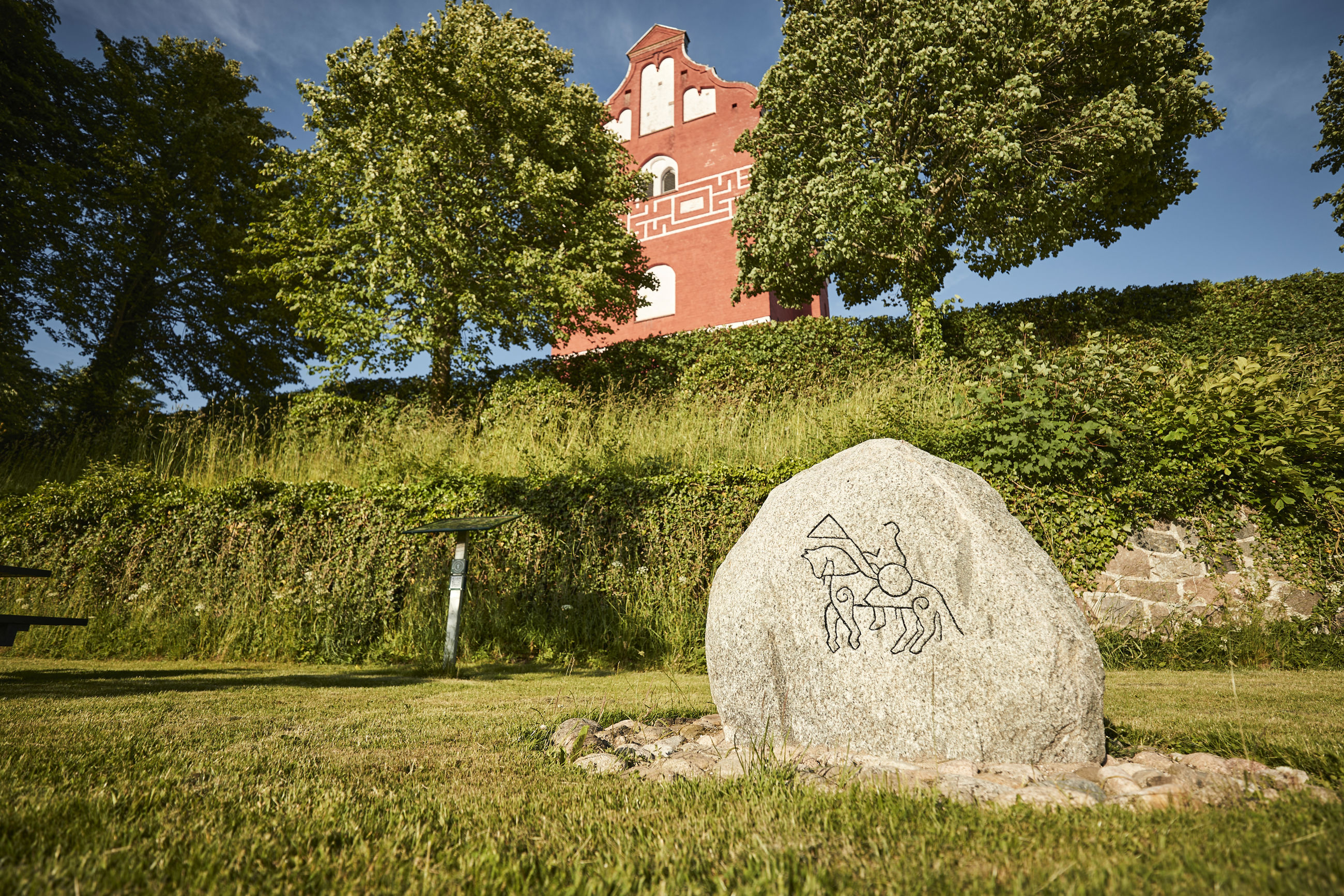 Ålum Kirke og sten med tegning af rytter på hest