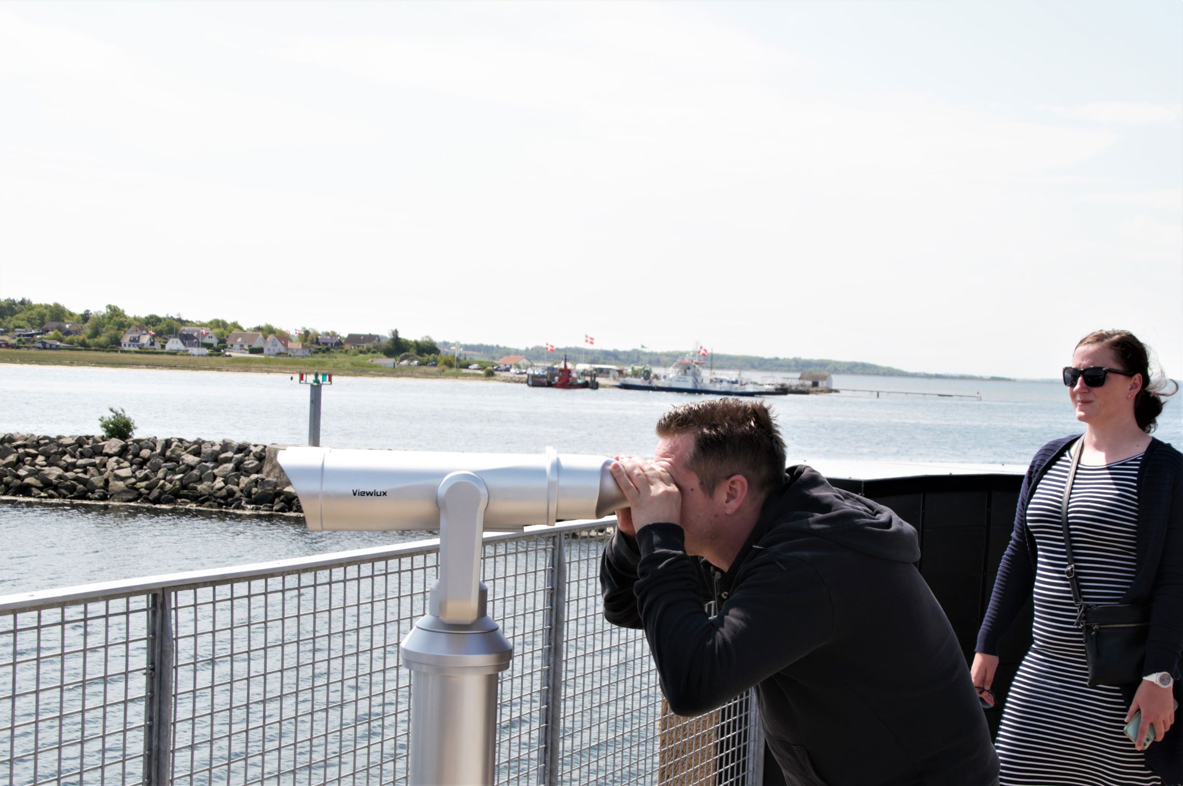 Personer kigger i kikkert ud over fjorden Kanonbådens øvre dæk