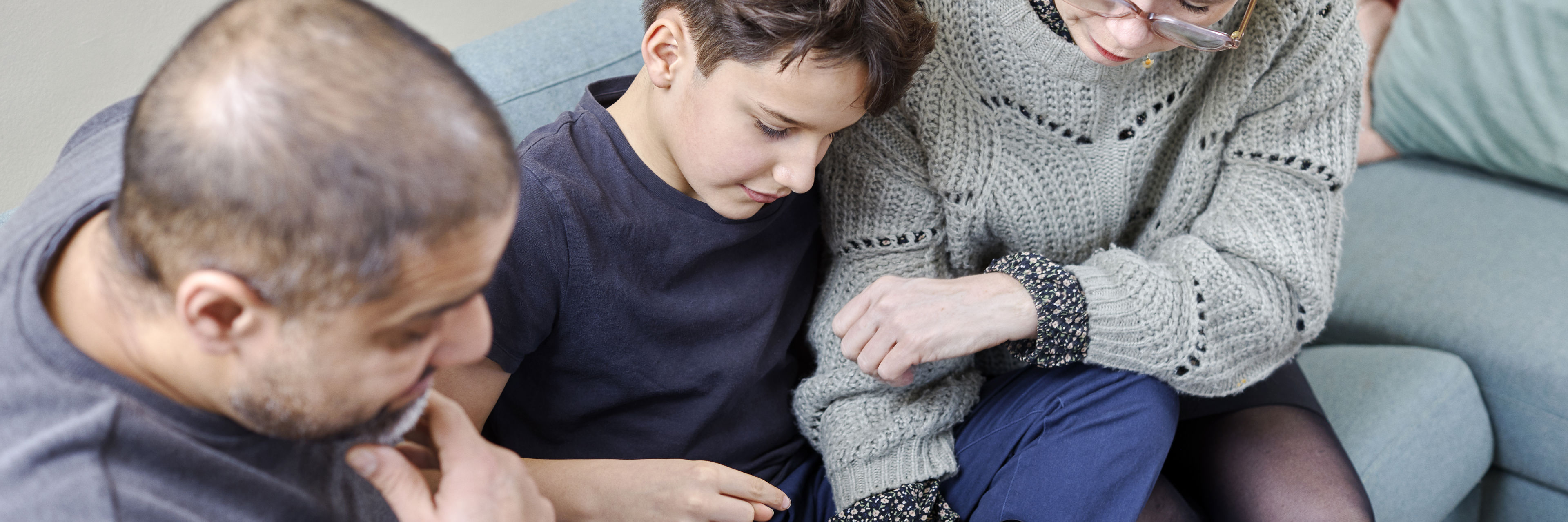 Forældre og barn der sidder i sofa og gennemgår Min Magiske Mave forløb på ipad