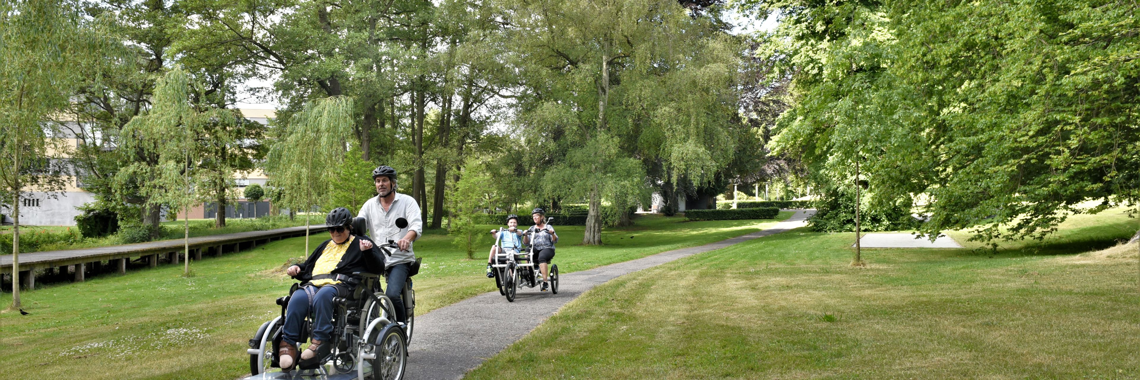 Borger i kørestol er på tur med hjælper på handicapcykel.