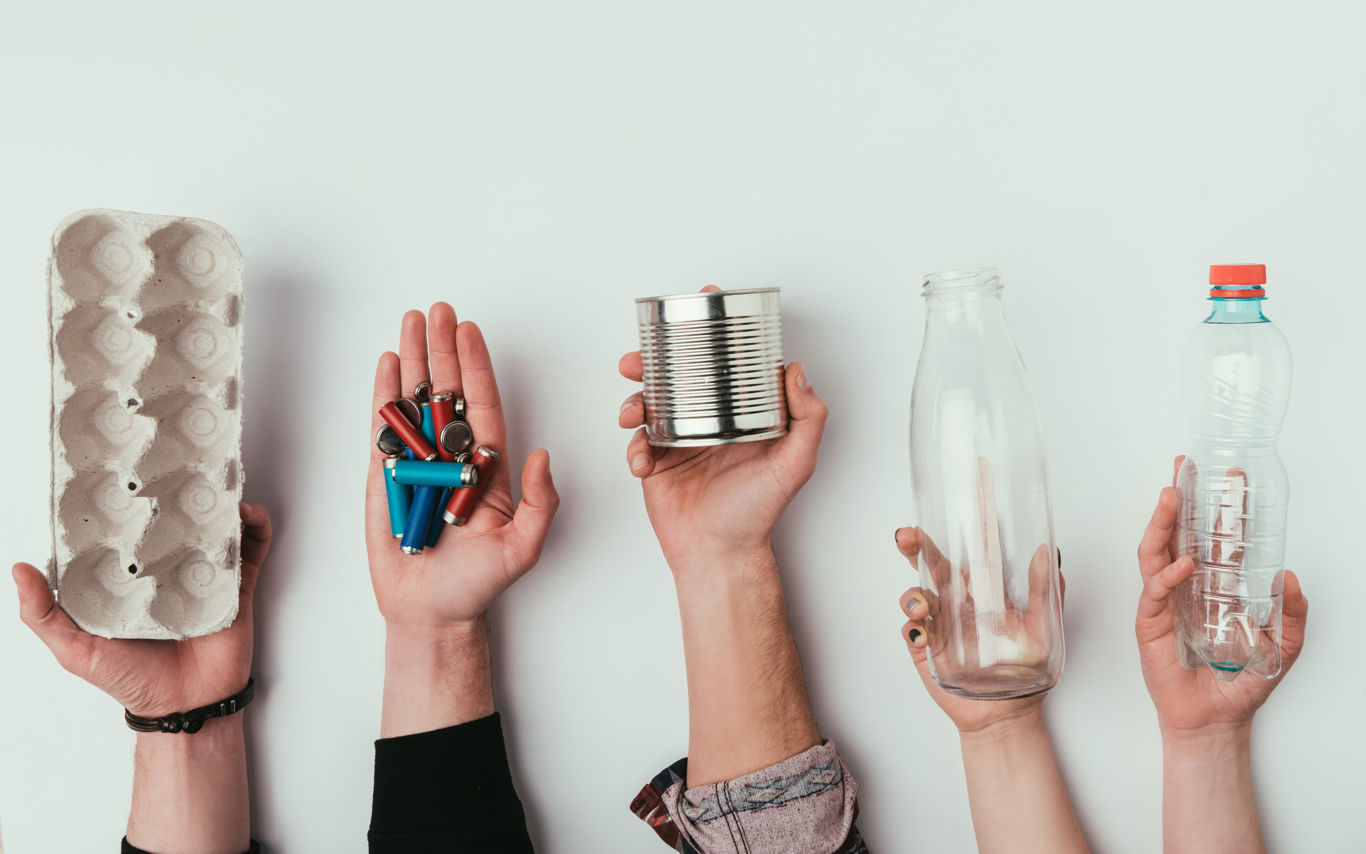 Hænder der holder forskellige slags affald