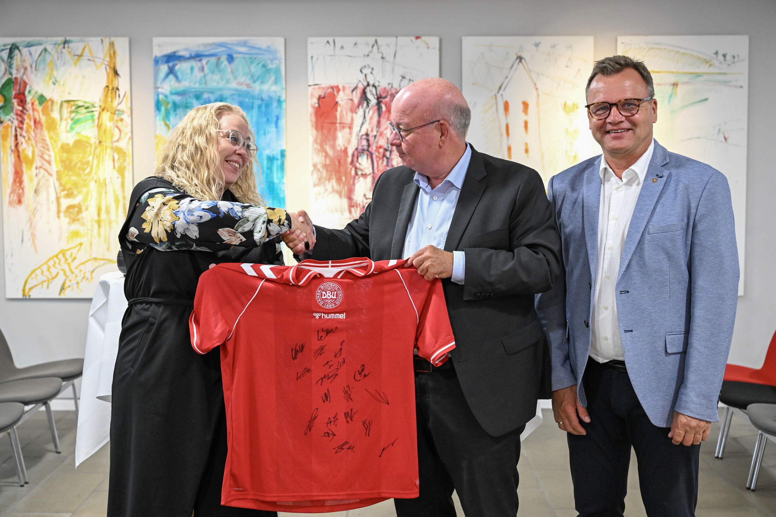 Borgmester i Randers Kommune, Rosa Lykke Yde, formand for DBU, Jesper Møller og formand DBU Jylland, Ole Ladefoged skriver under på aftalen (på foto fra venstre til højre). Inden da modtog borgmesteren en signeret landsholdtrøje i gave af DBU. Foto: Randers Kommune