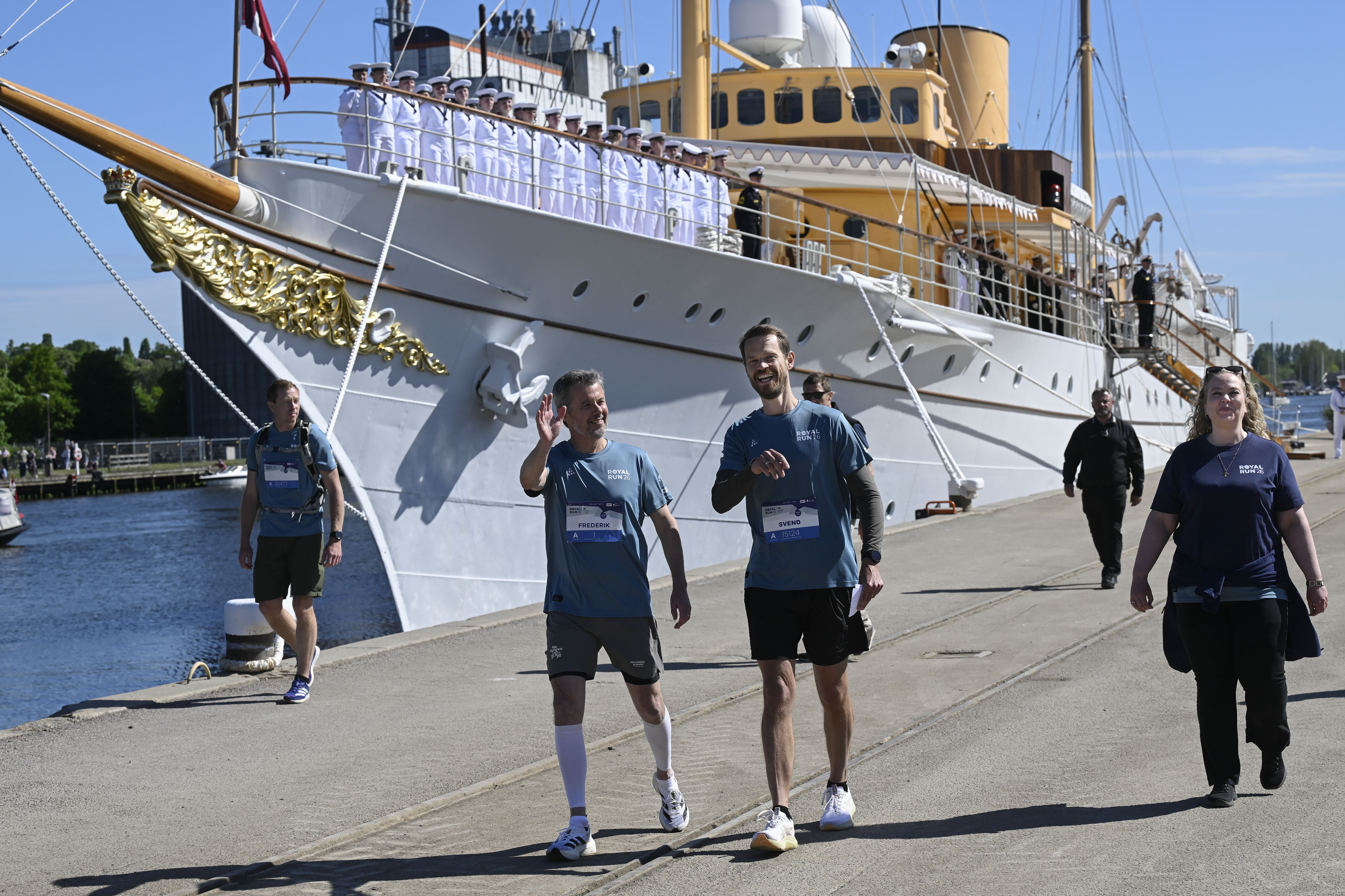 Kongen vinker til de fremmødte på Randers Havn, hvor han går sammen med Svend Brinkmann og Rosa Lykke Yde
